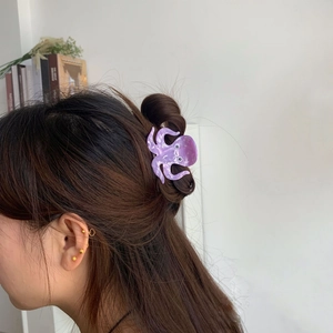 Detailed view of a purple marble acetate octopus hair claw clip on brunette hair