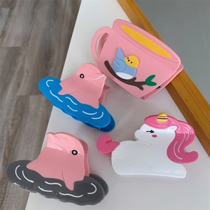 Macro shot of cute acetate hair claws in cartoon dolphin, pony, and coffee cup designs