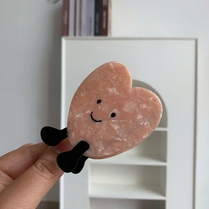 Molla per capelli a cuore in acetato rosa marmorizzato con dettaglio viso sorridente