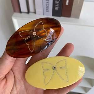 Oval geometric hair clips with crystal butterfly detail in amber and yellow colors