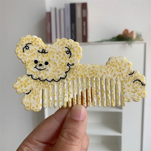 Detail of cute dog-shaped hair comb with tortoise acetate pattern in cozy home setting