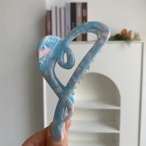 Close-up of heart-shaped cellulose acetate hair claw with blue and pink marble texture
