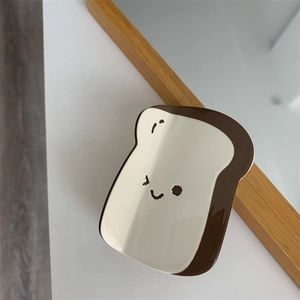 Dettaglio della molletta per capelli in acetato a forma di toast con sorriso cartoon