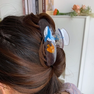 Detail of a large shark hair claw clip with acetate ocean animals worn on long hair
