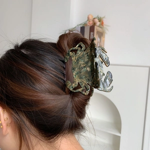 Pince à cheveux crabe vert marbré portée par un mannequin aux cheveux longs