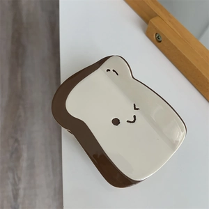 Vista dettagliata della molletta per capelli in acetato a forma di toast con smiley