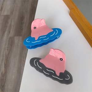 Close-up of pink dolphin claw clips with wave bases in blue and grey finish