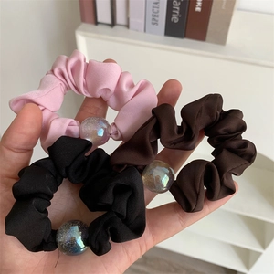Three-piece set of satin scrunchies in black, pink and brown with iridescent bead charms