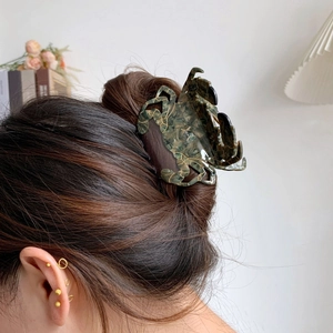 Détail d'une pince crabe gris foncé avec texture marbrée dans les cheveux