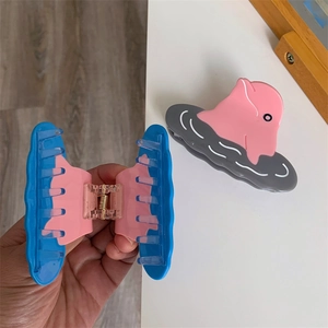Detail showing dolphin hair claw clips in pink blue and pink grey colors