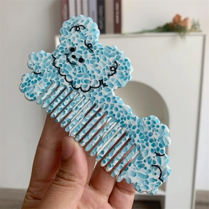 Close-up of cute cartoon dog hair comb made of premium blue and white acetate