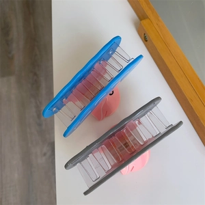 Top view of sky blue and grey matte hair claw clips with pink inserts on white surface