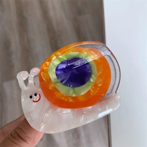 Détail d'une pince à cheveux créative en forme d'escargot en acétate avec coque colorée