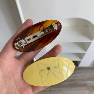 Oval geometric hair clips with amber texture and yellow butterfly rhinestone pattern