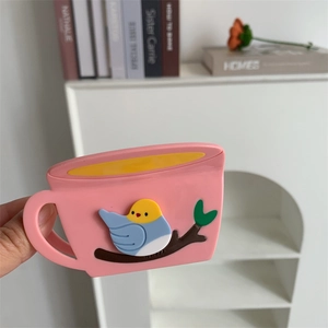 Pink cup-shaped acetate hair claw clip with colorful bird and tree branch relief detail