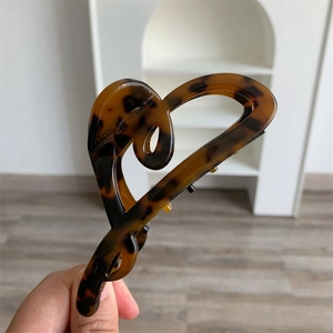 Macro detail of large acetate hair claw clip with vintage tortoiseshell heart shape