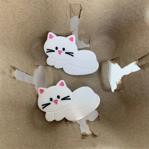 Vue macro d'adorables pinces à cheveux chat en résine blanche avec des détails roses