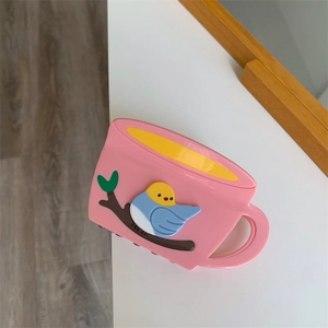 Detailed view of pink coffee cup hair claw clip with colorful bird 3D relief design