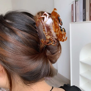 Grande pince à cheveux en forme de crabe avec motif écaille sur une chevelure