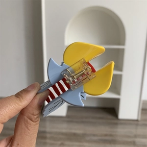 Détail d'une pince à cheveux en acétate multicolore montrant la résine bleu ciel et jaune