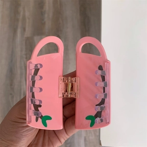Pink purse-shaped hair claw clip with green leaf pattern and durable metal spring detail