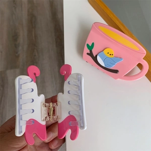 Detail of pink and white acetate hair claw clip showing the strong metal spring and teeth