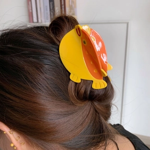 Détail de la pince à cheveux poisson jaune pour fixer les cheveux sur un modèle