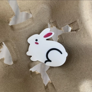 Détail d'une pince à cheveux lapin blanc en acétate avec finitions roses brillantes