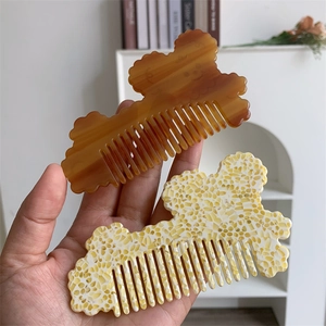 Close-up of cute bear-shaped hair combs made of amber and floral acetate material