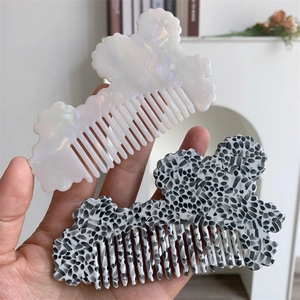 Detail of cloud-shaped acetate hair combs in pearlescent white and marble patterns
