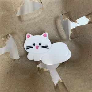 Détail d'une pince à cheveux chat blanc mignon en acétate sur papier rustique