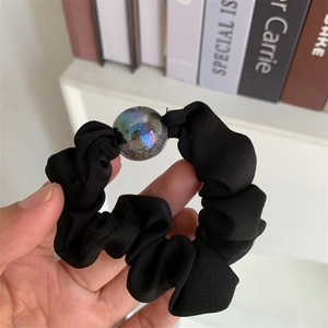 Detail of black chiffon scrunchie with a shimmering iridescent glitter decorative bead