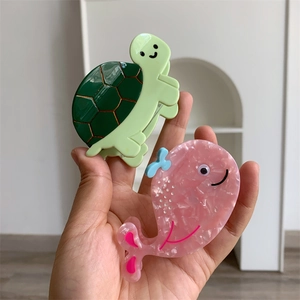 Detail showing green sea turtle and pink whale acetate hair claws for women