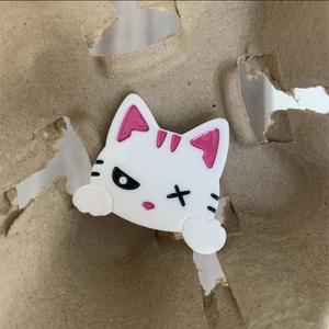 Détail d'une pince à cheveux chat blanc en acétate avec des détails rose vif
