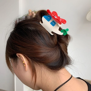 Détail d'une pince à cheveux hélicoptère mignonne sur cheveux bruns foncés en demi-queue