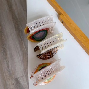 Détail macro de pinces à cheveux en acétate en forme d'escargot, motifs léopard et colorés