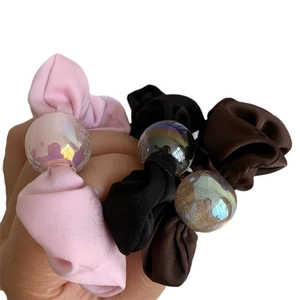 Three-piece satin scrunchies set in pink, black, and brown with shimmering aurora beads