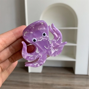 Close-up of a purple octopus hair claw clip with marble pattern and creative design