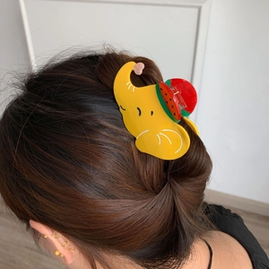 Pince à cheveux éléphant jaune avec pastèque, portée sur une queue de cheval basse