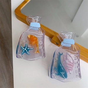 Close-up of ocean-themed acetate hair claws featuring colorful starfish and goldfish charms
