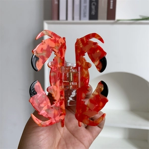 Gros plan détaillé d'une grande pince à cheveux crabe marbré rouge avec ressort doré