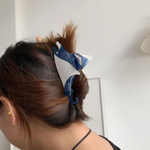 Blue and white manta ray hair claw clip in acetate material shown on model's hair