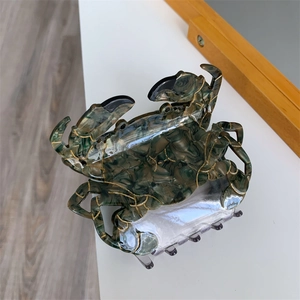 Vue détaillée de la grande pince à cheveux crabe avec texture marbrée et lignes dorées