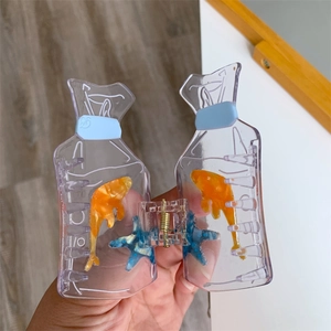 Detail of creative goldfish water bag hair claw clip with orange fish and blue starfish