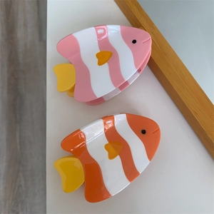 Détail des pinces à cheveux poisson avec motifs rayés et finition en acétate brillant