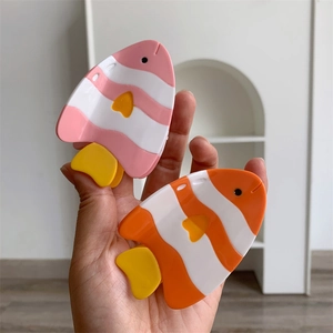 Détail de pinces à cheveux en forme de poisson coloré à rayures roses et oranges