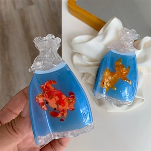 Macro detail of acetate hair claw clips shaped like goldfish and crab in water bags