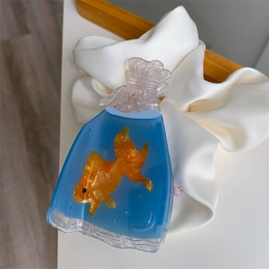Detailed close-up of a goldfish in a water bag resin hair claw clip on silk backdrop