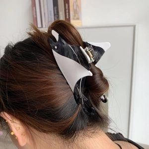 Detail view of the black and white acetate manta ray hair claw clip in long hair
