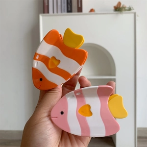 Détail de pinces à cheveux poisson colorées en orange et rose avec finition acétate